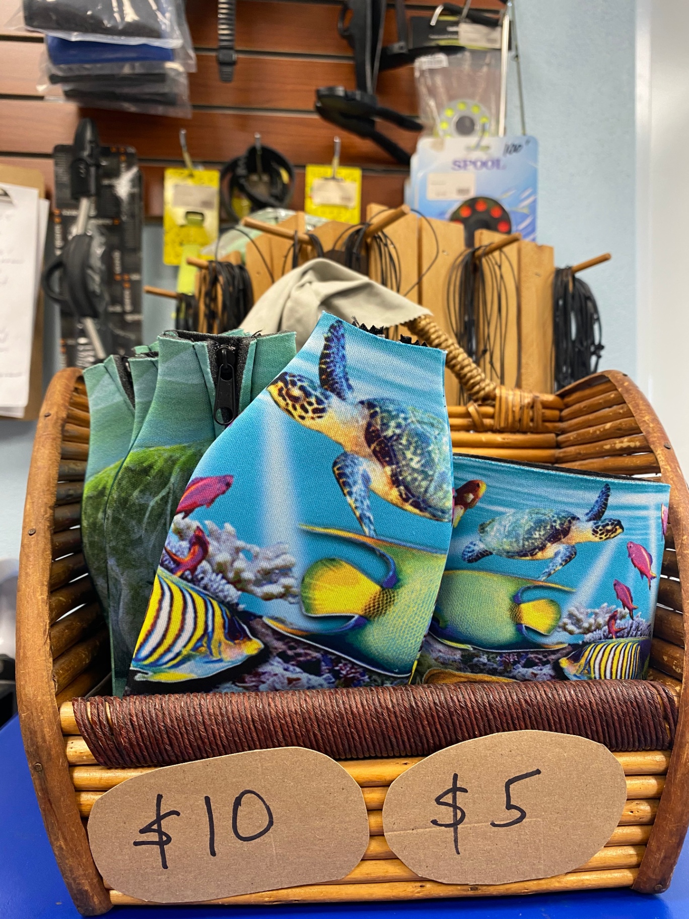 Reef-print neoprene koozies in a basket at the counter